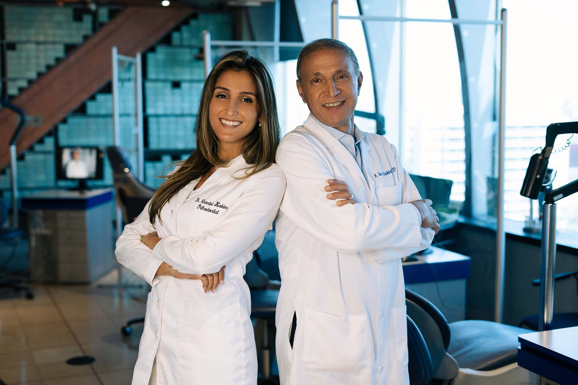 Dr. Isaac Hakim and Dr. Chantal Hakim standing back to back as the best orthodontist team in Los Angeles CA.