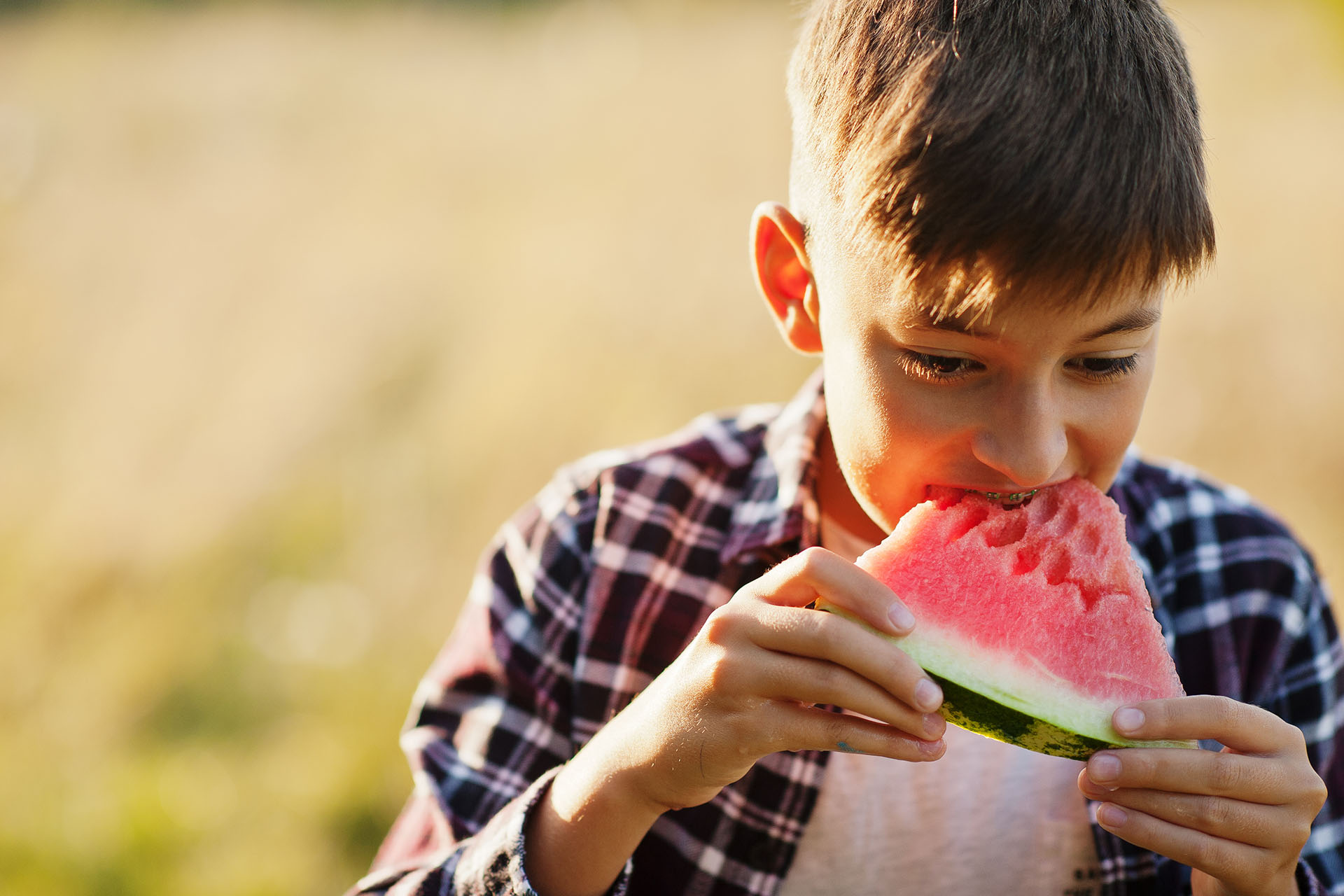  Pediatric orthodontic patient eating watermelon because he knows there are foods to avoid when wearing braces 