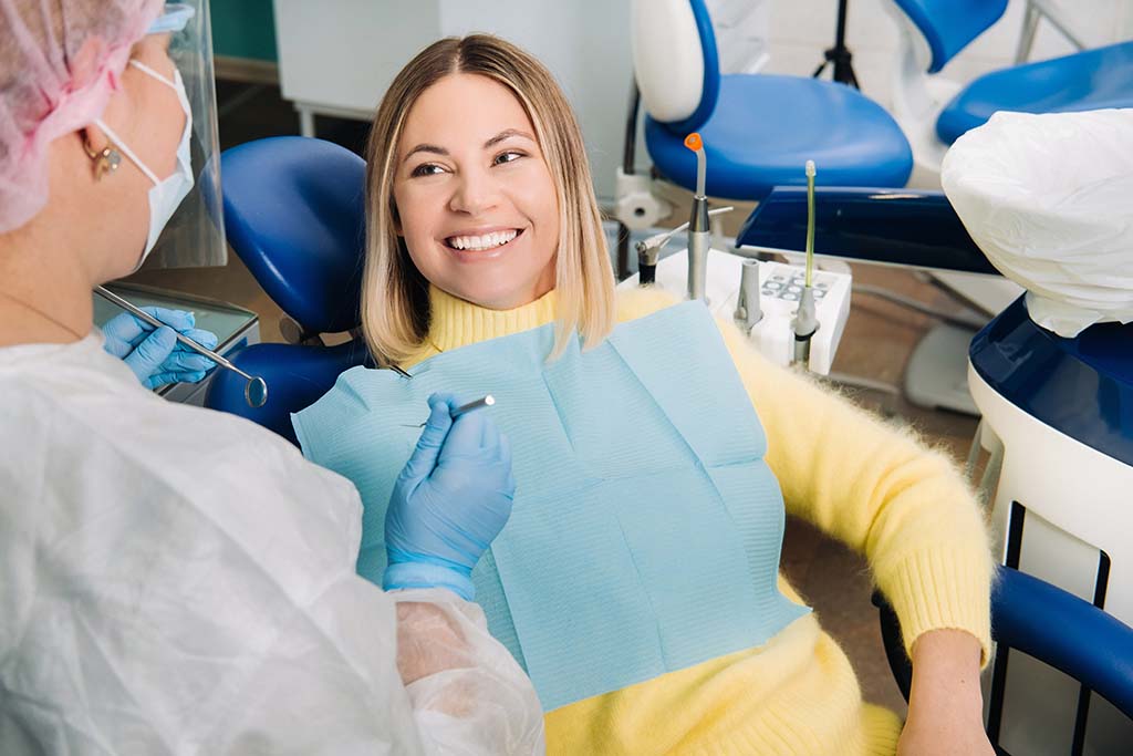 woman in the dentist chair smiles at the dentist