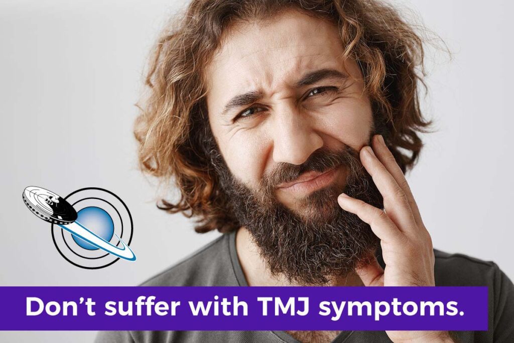 Man with TMJ symptoms holding his jaw as he seeks TMJ treatment