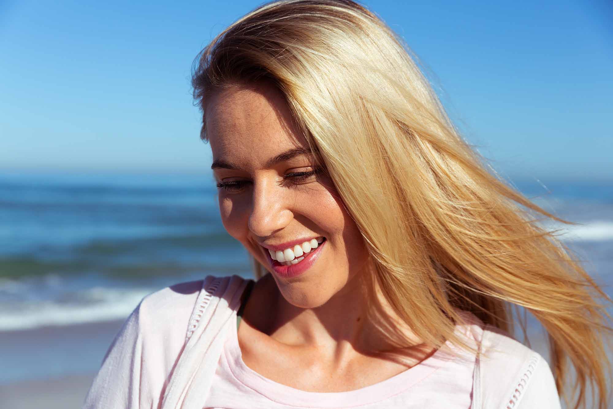 woman shows off her beautiful smile on the beach