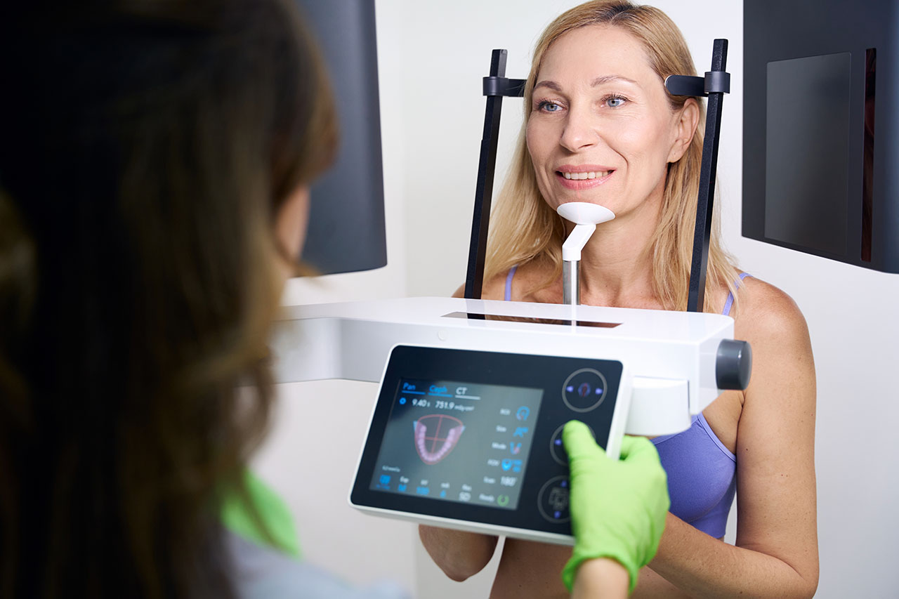 Female patient getting scanned by a CBCT (Cone Beam Computed Tomography) scanner, a sophisticated 3D imaging technique that allows us to gain a complete, three-dimensional view of your dentofacial structure