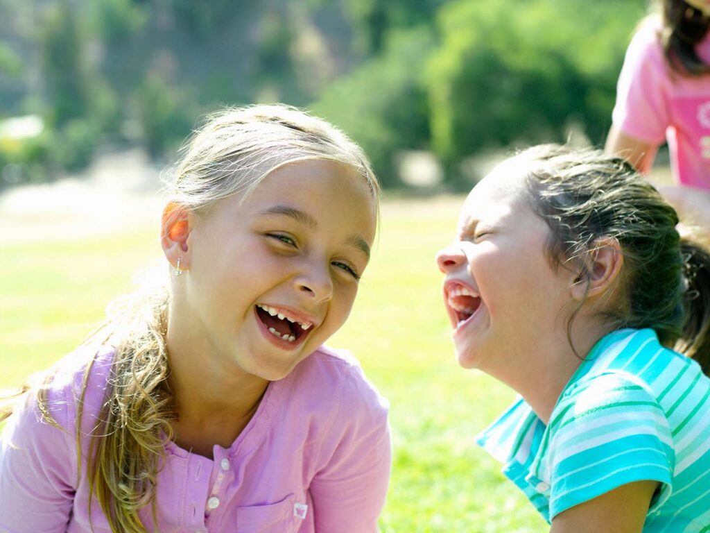 two laughing girls outside for recess