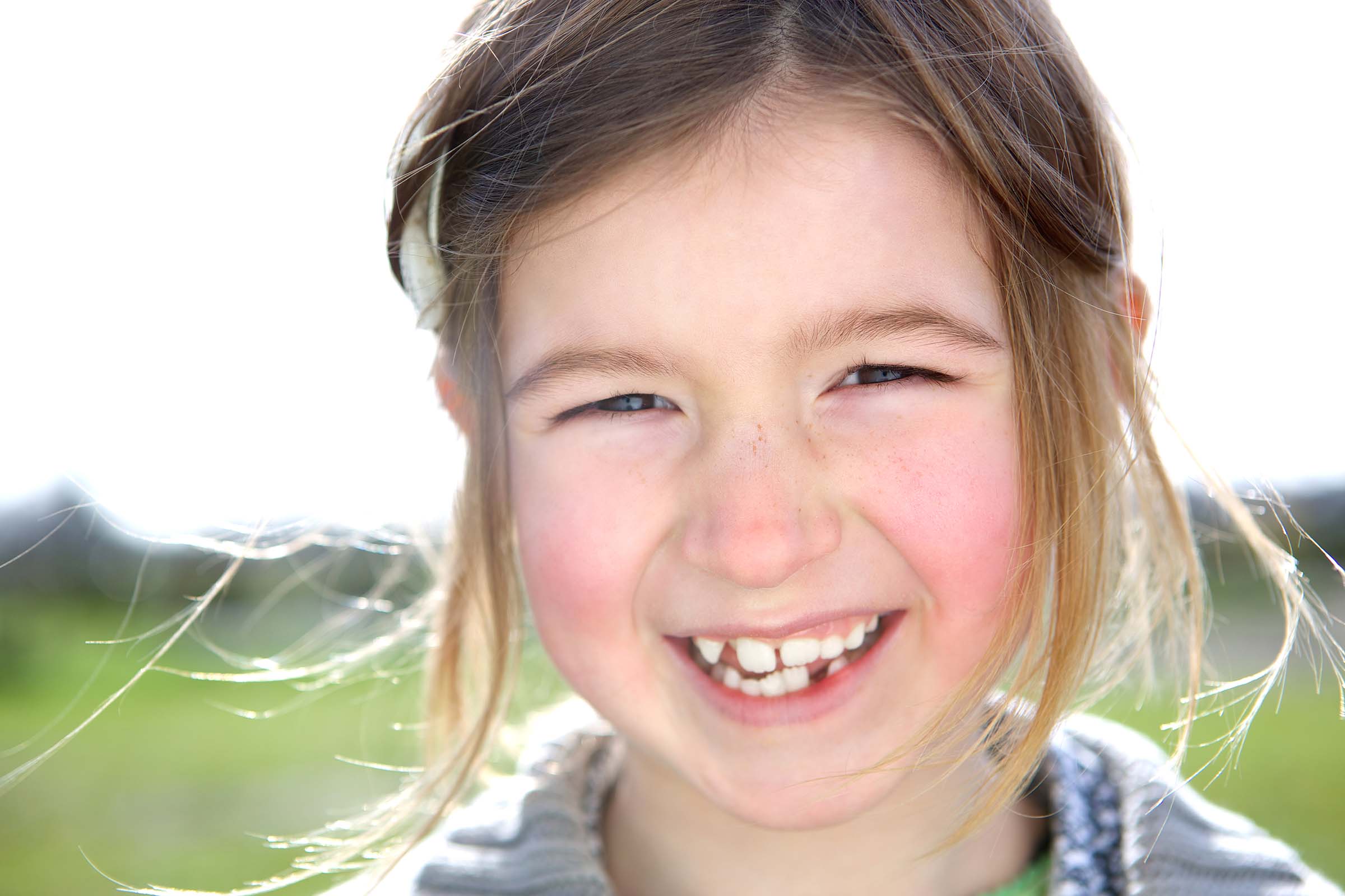 smiling young girl on the soccer field with gaps between her teeth